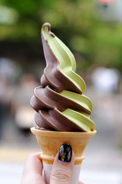 在日本享用绿茶冰淇淋蛋筒一个拿着双色冰淇淋蛋筒的女孩