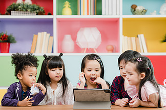 一群孩子在课堂上使用平板电脑，多<i>民</i>族的男孩和女孩很高兴在小学使用技术学习和玩游戏。孩子们将技术用于教育理念。