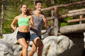 年轻运动夫妇在山上跑步的照片