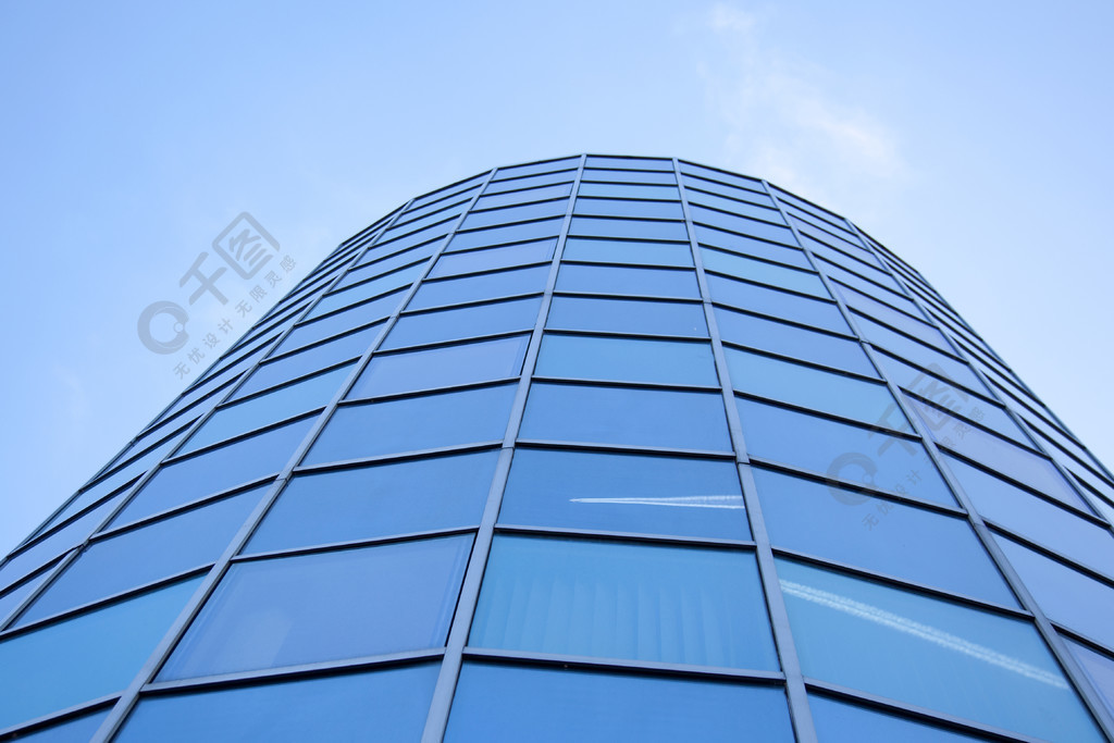 圆形办公室的玻璃幕墙与蓝天和飞机的反射