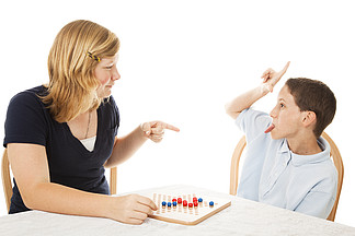 小弟弟在玩棋盘游戏时把他十几岁的妹妹逼疯<i>了</i>。在白色上隔离。