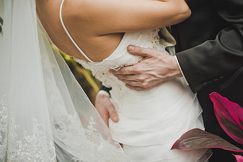 男人抱住身着白色连衣裙的女人,腰和屁股 新娘的背影