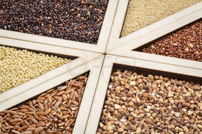 木托盘中的各种无麸质谷物（红和黑藜麦、荞麦、褐河、苋菜和小米），重点放在荞麦和大米上