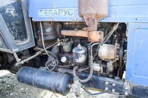 俄罗斯，Temryuk-2015 年 7 月 15 日： 拖拉机。农业机械拖拉机。带电器的发动机拖拉机。这张照片是在 Temryuk 郊区一个农村车库的拖拉机停车场拍摄的。带电器的发动机拖拉机。