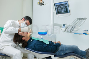欧洲男性牙医为一名 40 岁男子做检查的照片