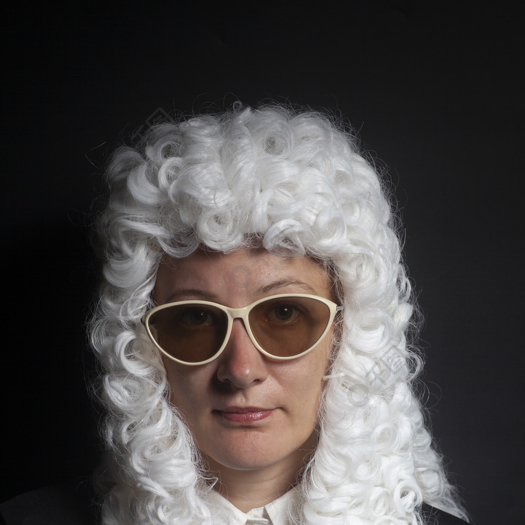 女法官戴着假发和黑色斗篷戴着黑色背景上孤立的太阳镜戴着假发和黑色