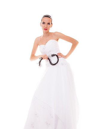 婚礼当天。身穿白色连衣裙、黑色皮革鞭打鞭子的全长年轻迷人新娘与白色背景隔离