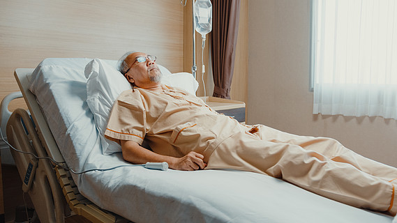 生病的老人躺在医疗诊所住院健康保险或款待概念