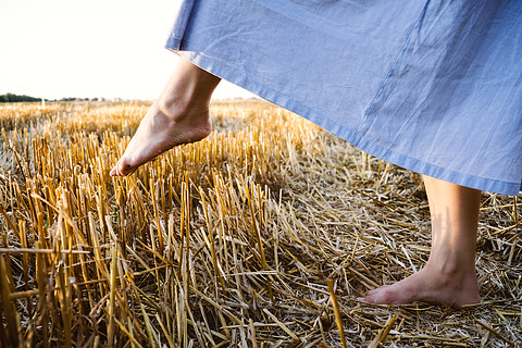 克服障碍抑郁症的概念一个女人光着脚踩在一根尖刺的稻草上
