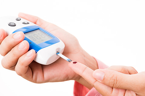 特写手妇女用血糖仪测量血糖测试水平检查手指上的血液,她监测和控制