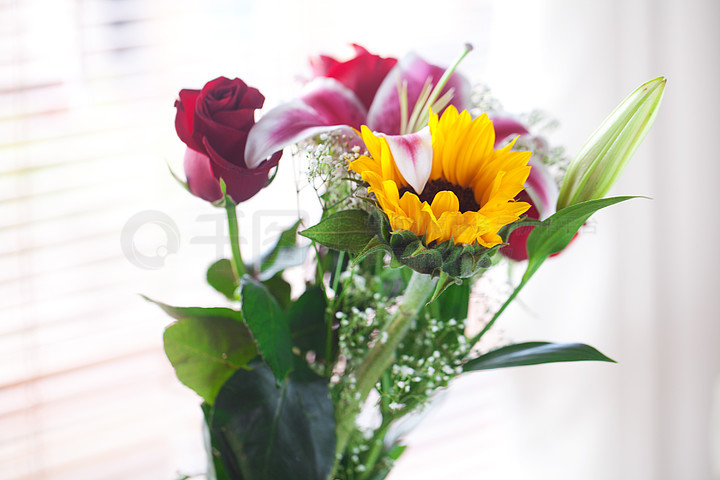 花瓶里的向日葵,百合和玫瑰美丽的花束