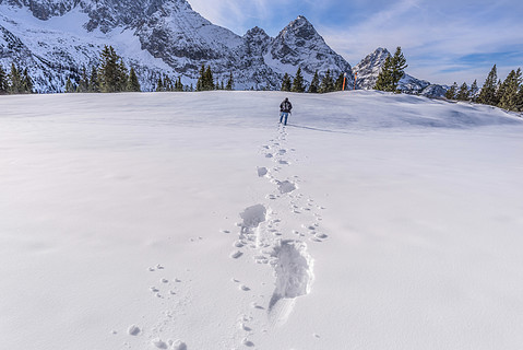 冬天的风景,一个人在山峰上穿过雪地,在他身后留下了足迹