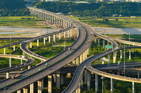 在复杂的高速公路或高速公路上行驶的汽车的鸟瞰图与树木。建筑和交通概念结构中的桥梁道路或街道。顶视图。都市城市，日落的台中，台湾。