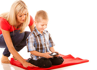 家庭、儿童、<i>父</i><i>母</i><i>身</i>份、技术和互联网概念。<i>母</i>子在智能手机上玩电子游戏，与白色隔离