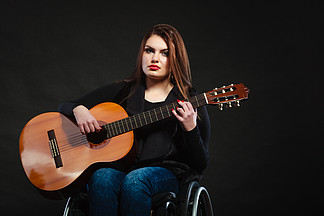 弹吉他的残疾女孩。.?弹吉他的残疾女孩。轮椅上的年轻女<i>音</i><i>乐</i>家。爱好<i>激</i><i>情</i><i>音</i><i>乐</i>放松概念。