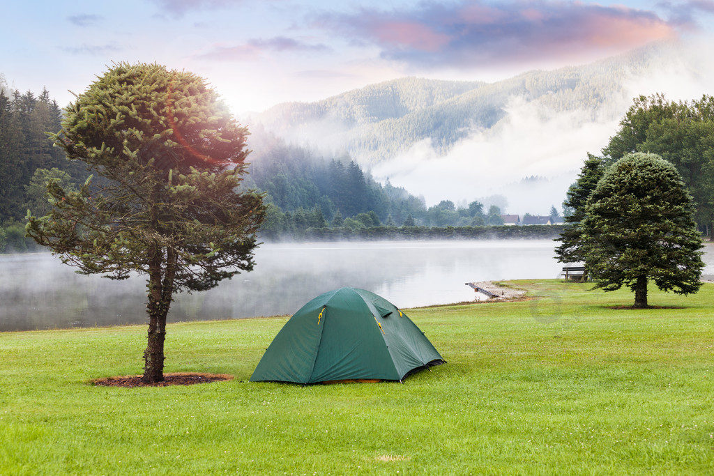 在高山湖附近露营。绿草草坪上的帐篷