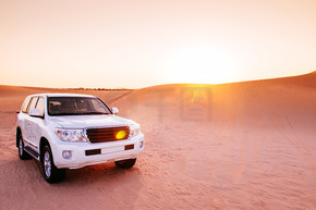 迪拜-阿布扎比的沙漠越野日落野生动物园。在 Al Wathba 甜点的 SUV 车反对日落或日出
