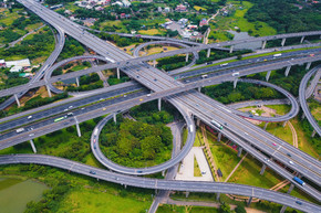 高速公路交叉口的鸟瞰图。桥路形状 8 号或无限标志与绿色花园和树木与建筑概念有关。顶视图。都市城市，日落的台北，台湾。