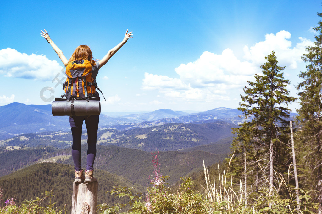 女孩徒步旅行者揹著揹包站在山脈和森林的背景上喀爾巴阡山脈烏克蘭