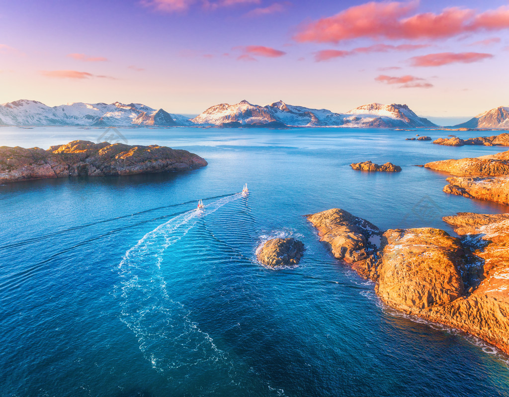 渔船鸟瞰图蓝色大海中的岩石挪威罗弗敦群岛冬季日落时分渔船蓝色大海