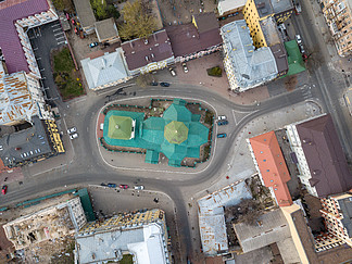 圣尼古拉斯普里斯蒂卡教堂圆顶、房屋屋顶和停放汽车的道路的顶视图，波多尔区。基辅，乌克兰。无人机照片。波多尔圣尼古拉斯普里蒂斯克区教堂的顶视图。基辅，乌克兰