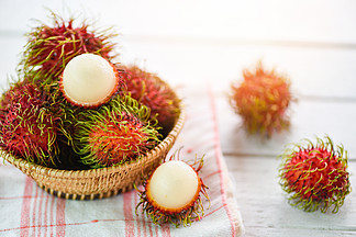红毛丹在桌子背景的篮子里<i>剥</i><i>皮</i>/泰国花园里的新鲜红毛丹夏季水果