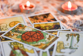 塔罗牌与烛光在黑暗背景下为占星术神秘魔法插图/魔法精神占星术和手掌阅读算命师概念
