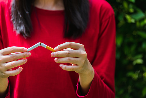 5 月 31 日世界无烟日,亚洲吸烟女性用手分解香烟,戒烟或戒烟概念