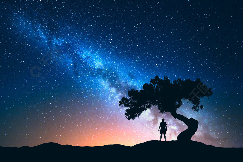 生长的树下的人的剪影自然背景与星空和美丽的银河蓝色银河和人宇宙