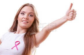 医疗保健、医学和乳腺癌意识概念。心满意足的年轻女子，胸前有粉红色的癌症丝带，做拇指手势，被白色隔离。女人胸前粉色癌症丝带竖起大拇指