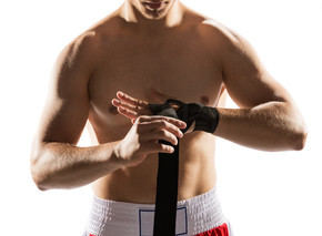 拳击手用绷带包扎双手。特写。拳击准备。搏击运动..拳击手用绷带包着双手