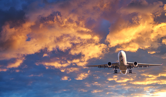 风景与白色客机,紫色天空与粉红色的云彩飞机起飞商务旅行