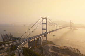 青马大桥鸟瞰图。香港公路在交通和旅游概念中具有悬挂式建筑结构。夕阳下的城市。