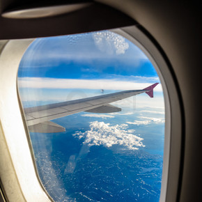 从飞机的窗户看到的云彩和天空。飞机飞越挪威斯堪的纳维亚半岛。