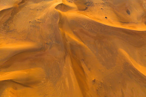 迪拜市、阿拉伯联合酋长国或阿联酋的沙丘红色沙漠野生动物园鸟瞰图。在日落时间的自然景观背景。著名的旅游胜地。沙子的图案纹理。顶视图。
