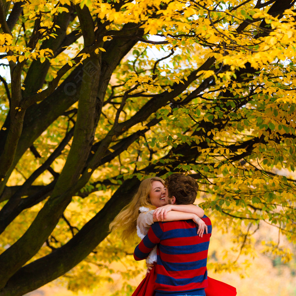 爱情年轻夫妇在公园见面在浪漫的约会中玩乐男人抱着女人在怀里拥抱和