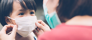 母亲带着面罩照顾女儿，在户外保护疾病流感或 covid-19，妈妈戴上带儿童安全的医用口罩，以保护流行病的<i>爆</i><i>发</i>，横幅网站。