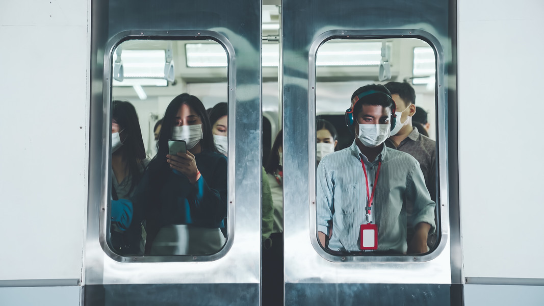 拥挤的公共地铁列车上戴着口罩的人群
