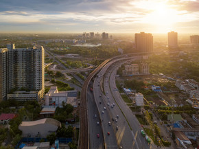 在高速公路交叉口行驶的汽车的鸟瞰图。建筑结构和交通概念中的桥梁道路。顶视图。都市城市，日落的曼谷，泰国。