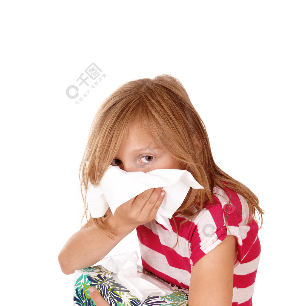 一个可爱的年轻金发女孩吹着流鼻涕手里拿着一个纸巾盒被白色背景隔离