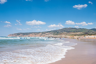 身份不明的人在夏季海滩和蓝色的海水上有冲<i>浪</i>板。夏季海滩全景
