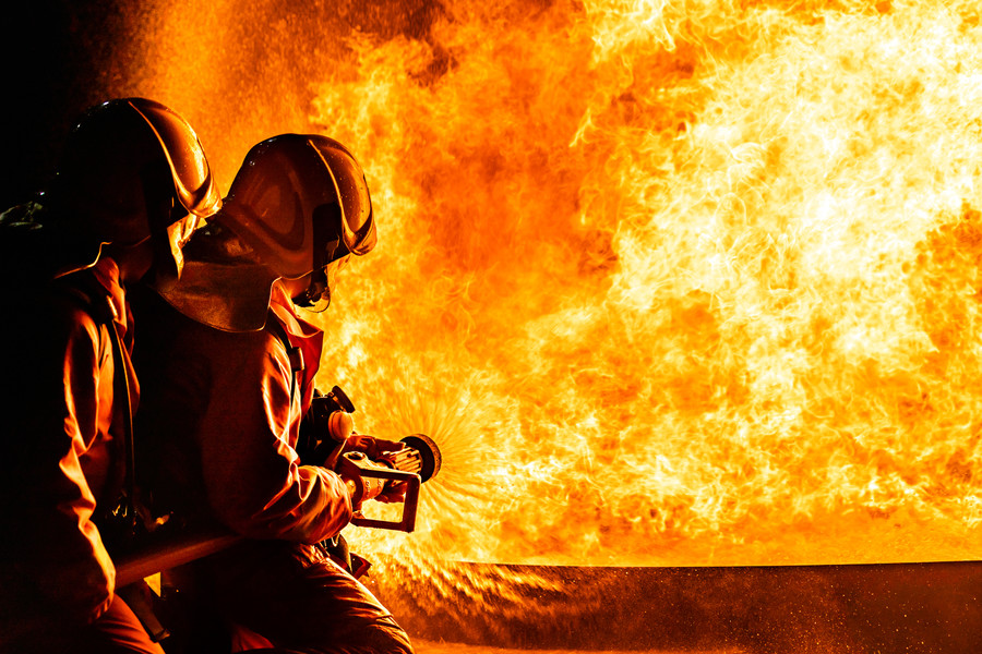 852消防员使用旋转式水雾式灭火器与油中的火焰进行灭火,以控制火势不