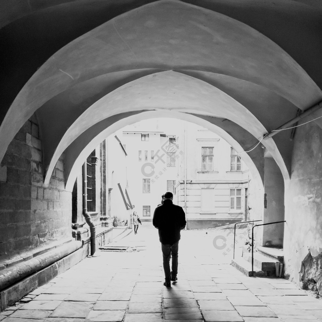 走在老狭窄的街道上的男性剪影黑白照片在大拱门下大拱门下走在老窄街