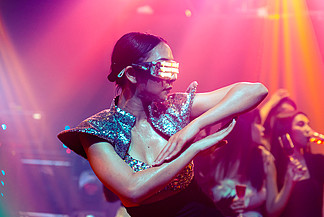 夜总会的技术舞者随着 DJ 的音乐节拍跳舞。 <i>EDM</i> 新年晚会和夜生活概念。