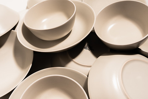 一组空而干净的陶瓷碗和盘子,具有简单的圆形和弯曲形状