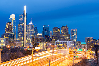 费城摩天大楼天际线城市景观在美国宾夕法尼亚州费城费城市中心建设暮光黄昏日落与高速公路城市道路交通。城市景观城市生活方式概念。
