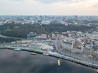 从无人机在基辅市中心历史部分的空中全景，以及波多尔区与邮政广场、酒店、教堂、河港。第聂伯河日落和多云天空的倒影。在多云的背景下，从第聂伯河右岸和乌克兰基辅市中心的波多尔区无人机拍摄的全景鸟瞰图天空。