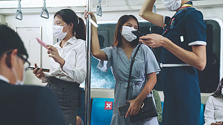 拥挤的公共地铁列车上戴着口罩的人群。冠状病毒病或 COVID 19 大流行病的爆发和高峰时间概念中的城市生活方式问题。