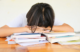 上记笔记并使用铅笔坐学习概念强调亚洲女学生参加考试期末并睡在书上