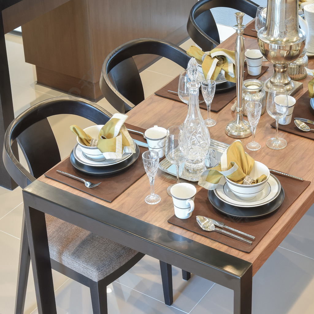 现代家居中的餐桌木桌和舒适的椅子配有优雅的餐桌布置